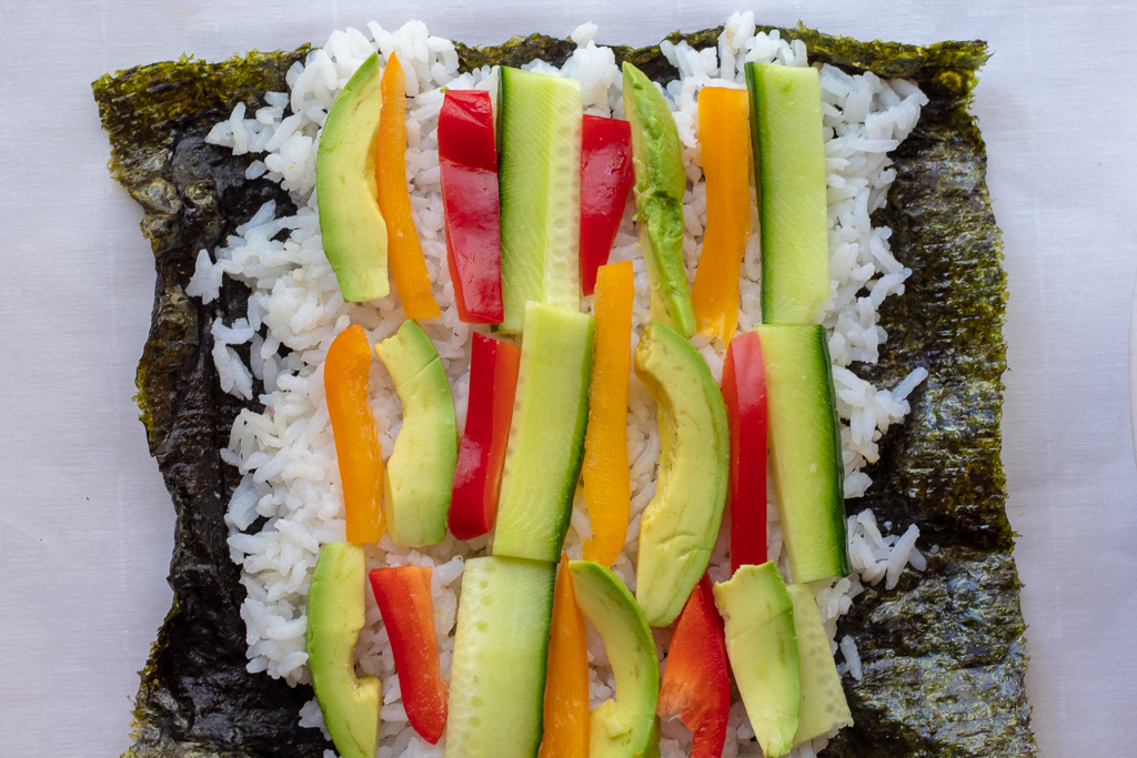 Nori sheet covered with rice and vegetables