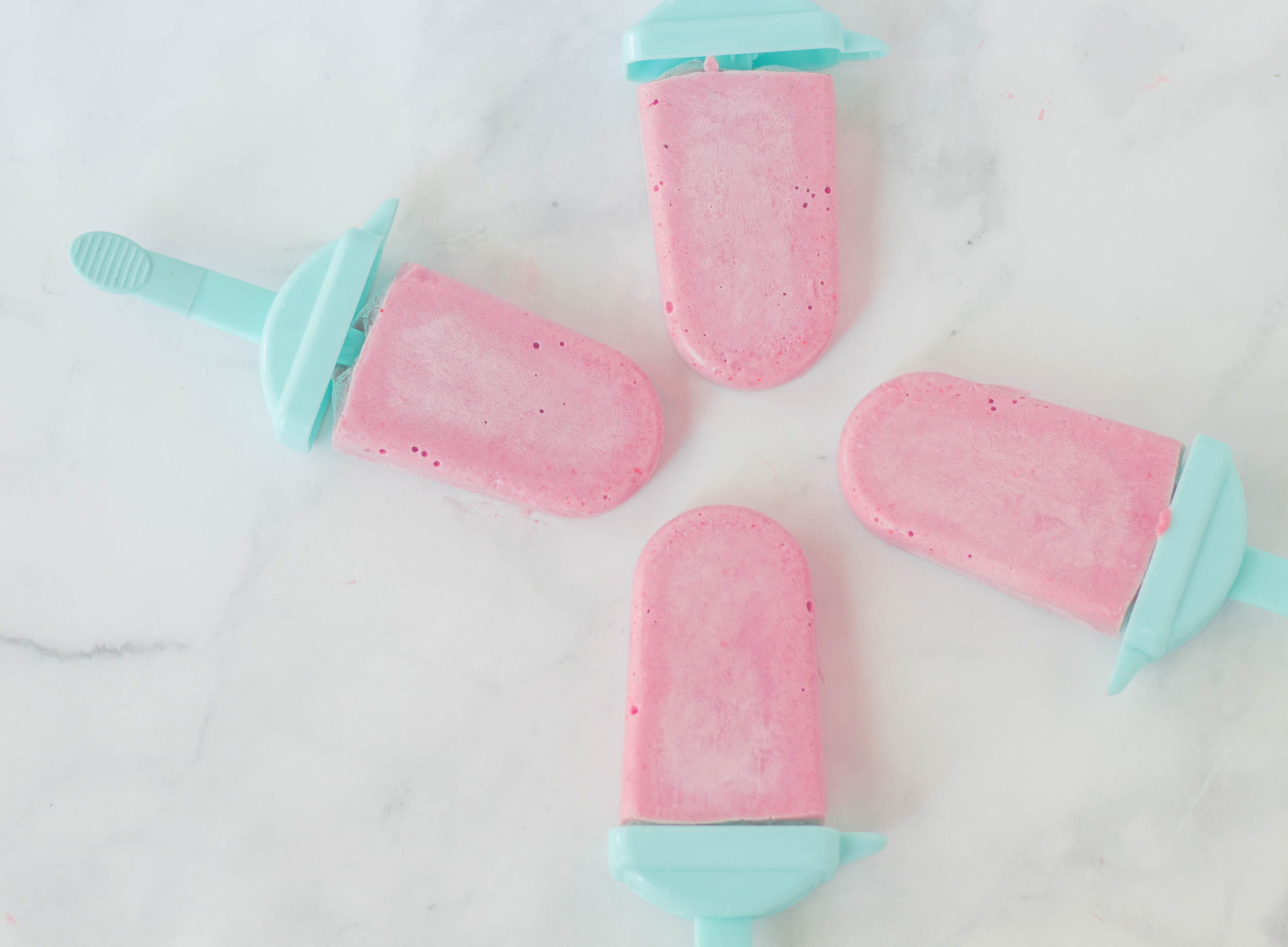 4 strawberry banana popsicles on the table